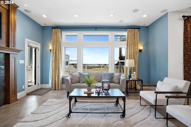 living area featuring light tile patterned flooring, recessed lighting, and baseboards