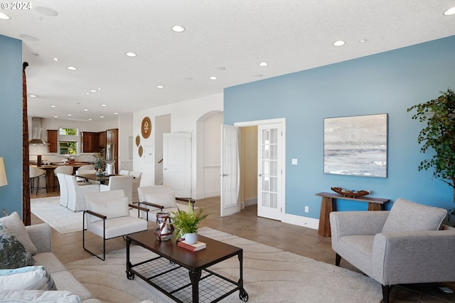 living area with light tile patterned flooring, recessed lighting, and arched walkways