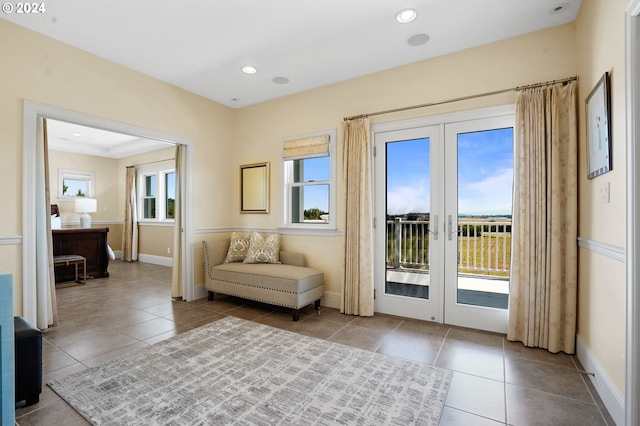 living area with tile patterned flooring, french doors, and baseboards