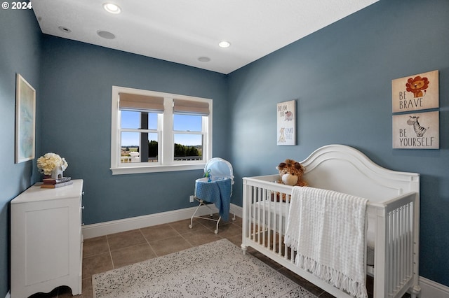 tiled bedroom with recessed lighting, baseboards, and a nursery area