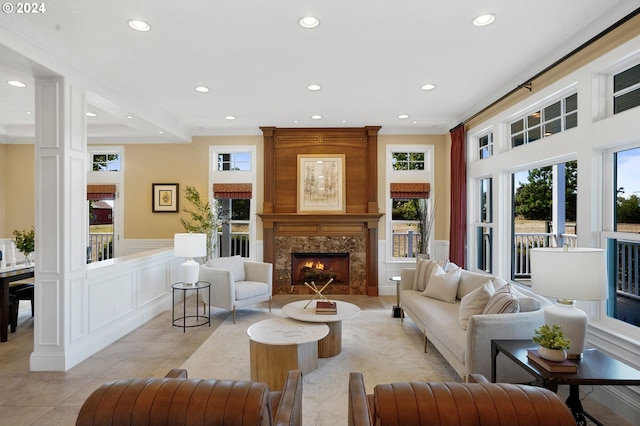 living room featuring a wainscoted wall, recessed lighting, a fireplace, light tile patterned flooring, and a decorative wall