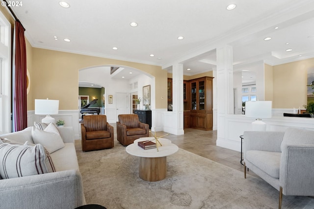 living room with ornamental molding, a wealth of natural light, and ornate columns