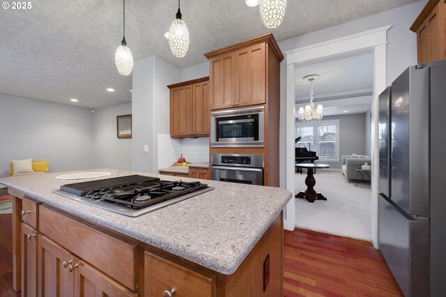 kitchen featuring a breakfast bar, sink, stainless steel appliances, and decorative light fixtures