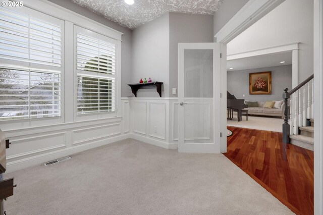 living area with light carpet and a textured ceiling