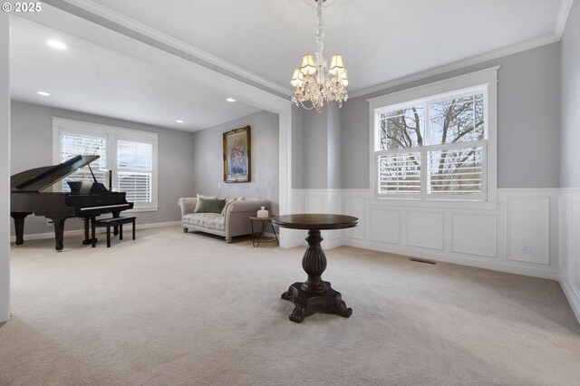 sitting room featuring carpet, crown molding, and an inviting chandelier