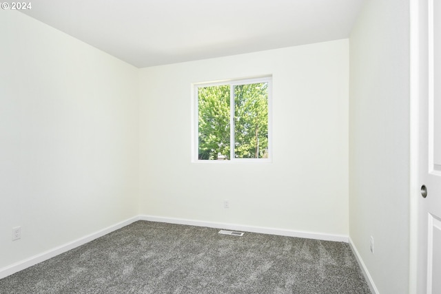 unfurnished room featuring dark carpet