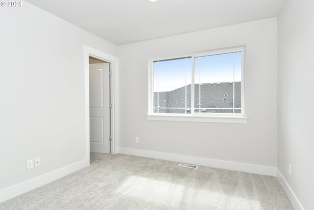 unfurnished room with light carpet