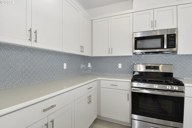 kitchen featuring appliances with stainless steel finishes, white cabinetry, and tasteful backsplash