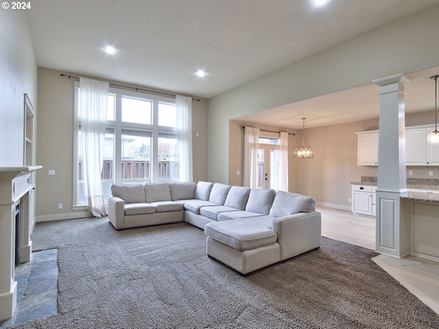 living room featuring light wood-type flooring, an inviting chandelier, and plenty of natural light