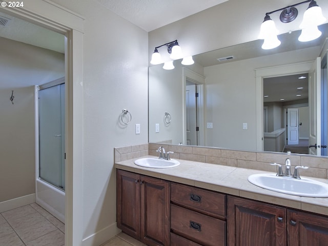 bathroom with tile patterned floors, vanity, and combined bath / shower with glass door