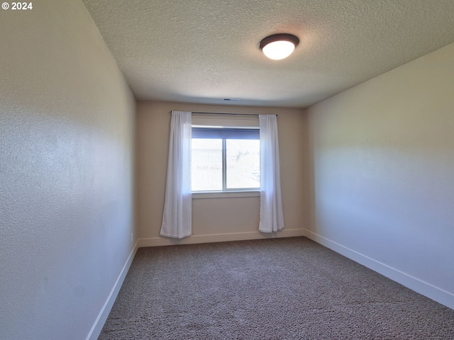 carpeted spare room with a textured ceiling