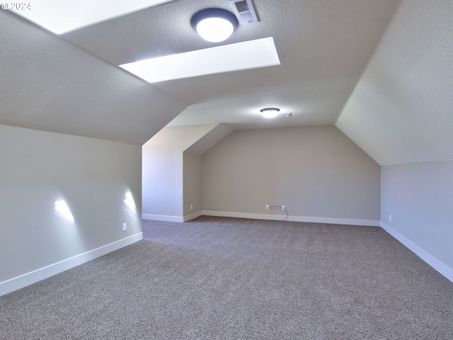 bonus room with carpet, a textured ceiling, and vaulted ceiling