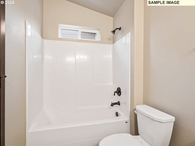 bathroom featuring vaulted ceiling, bathing tub / shower combination, and toilet