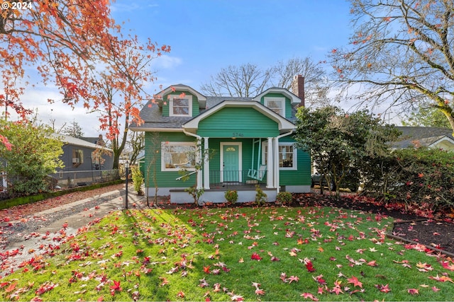 view of front of house featuring covered porch and a front yard