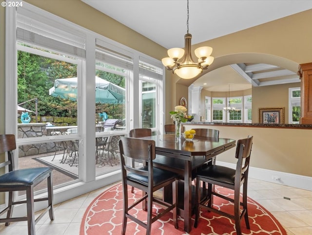 dining area with light tile patterned floors and an inviting chandelier