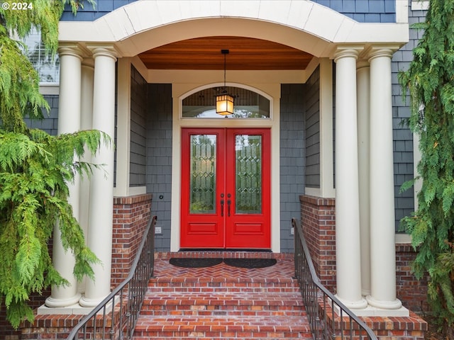 view of exterior entry featuring french doors and a porch