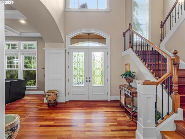 foyer featuring a high ceiling, wood-type flooring, and french doors