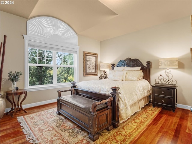 bedroom with hardwood / wood-style flooring and lofted ceiling