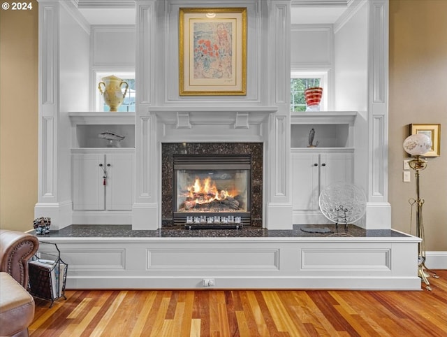 interior details with crown molding, hardwood / wood-style flooring, and a fireplace