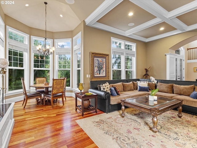 living room featuring coffered ceiling, beamed ceiling, an inviting chandelier, and light wood-type flooring