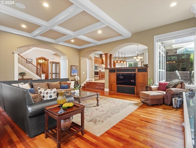 living room featuring beam ceiling, hardwood / wood-style floors, a notable chandelier, and coffered ceiling