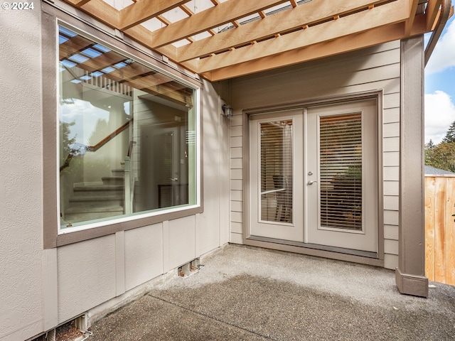 doorway to property featuring a patio area, a pergola, and french doors