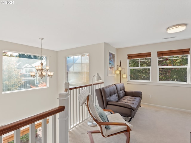 living area featuring a chandelier and carpet flooring