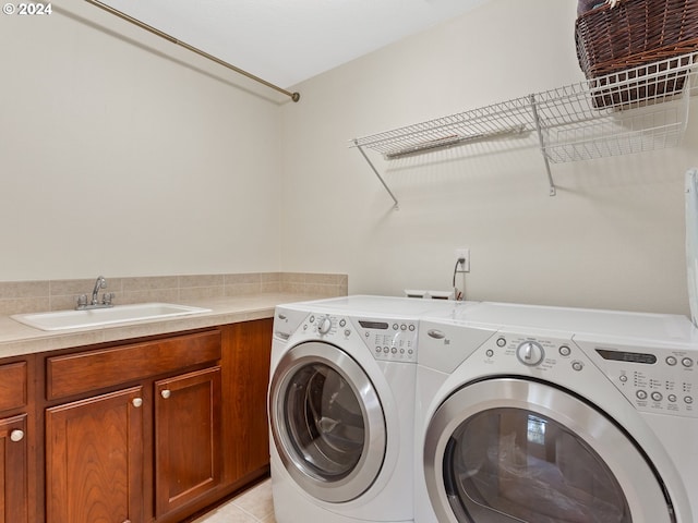 clothes washing area featuring sink, light tile patterned flooring, and independent washer and dryer