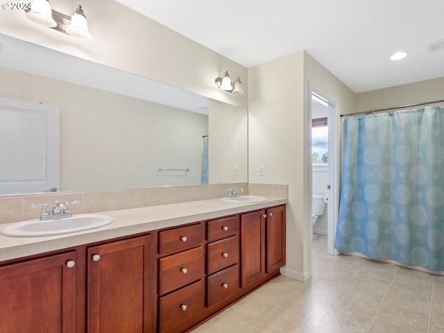 bathroom with walk in shower, vanity, and toilet