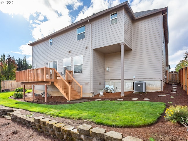 rear view of house featuring a wooden deck, a yard, and cooling unit