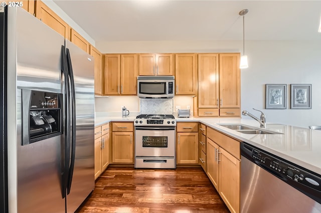 kitchen featuring light brown cabinetry, sink, decorative light fixtures, and appliances with stainless steel finishes