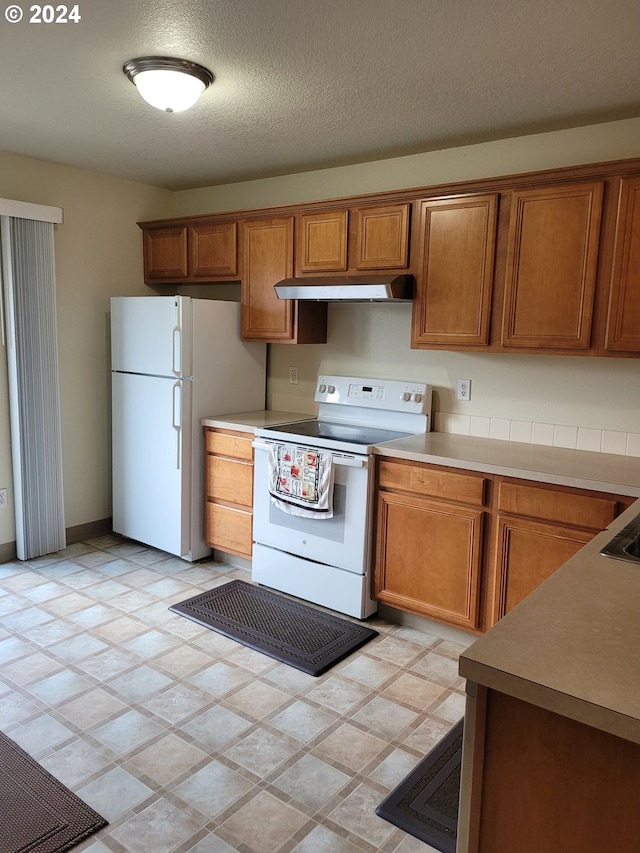 kitchen with white appliances and a textured ceiling