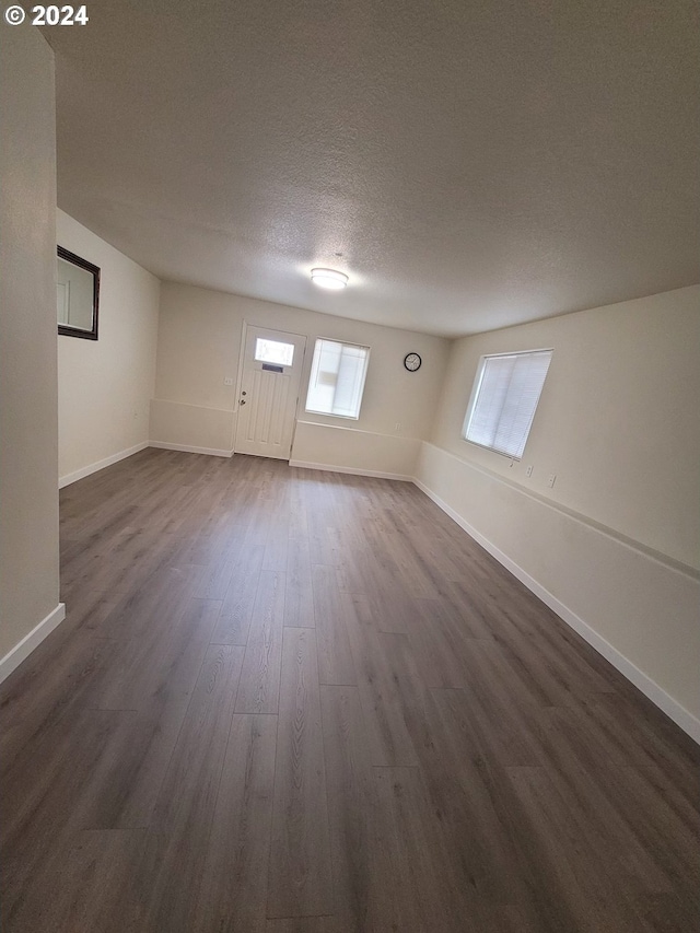 basement with a textured ceiling and dark wood-type flooring