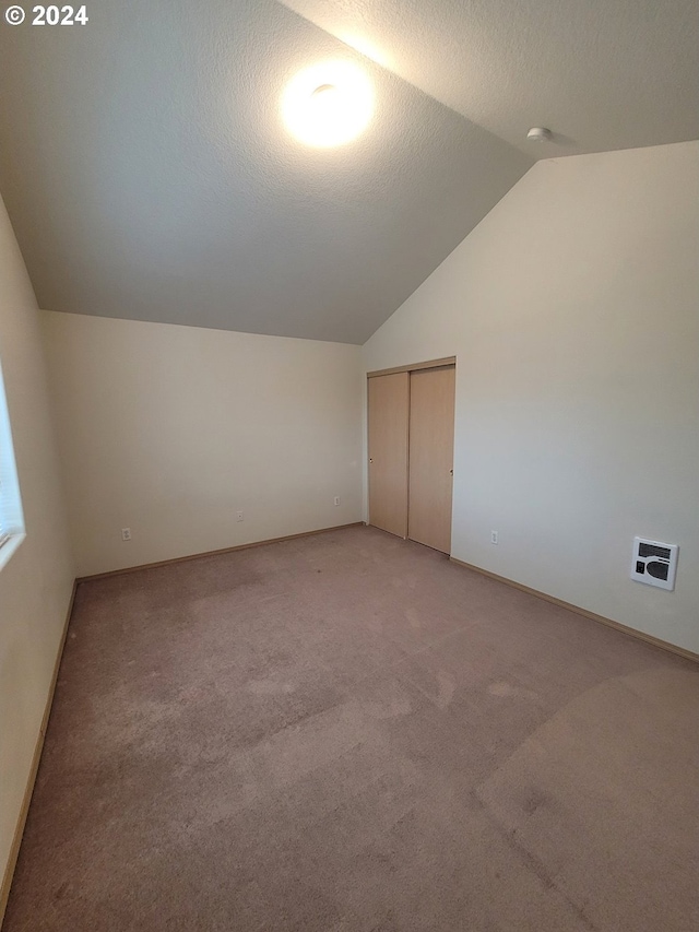 bonus room with a textured ceiling, carpet flooring, and vaulted ceiling