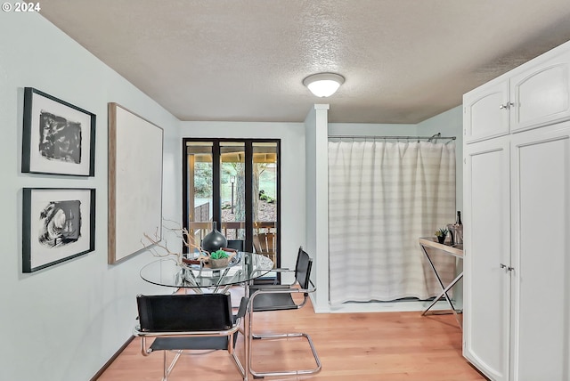 dining room with a textured ceiling and light hardwood / wood-style flooring