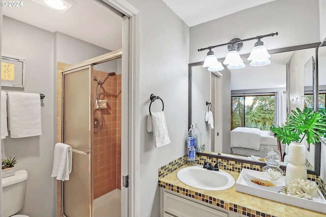 bathroom with vanity, tasteful backsplash, toilet, and an enclosed shower