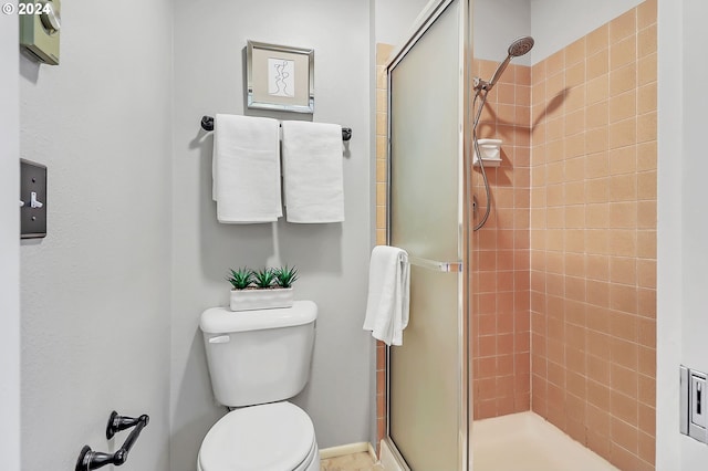 bathroom with toilet and a shower with shower door