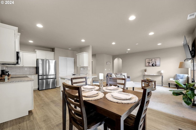 dining space featuring sink and light hardwood / wood-style floors