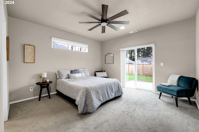 carpeted bedroom with multiple windows, ceiling fan, and access to outside