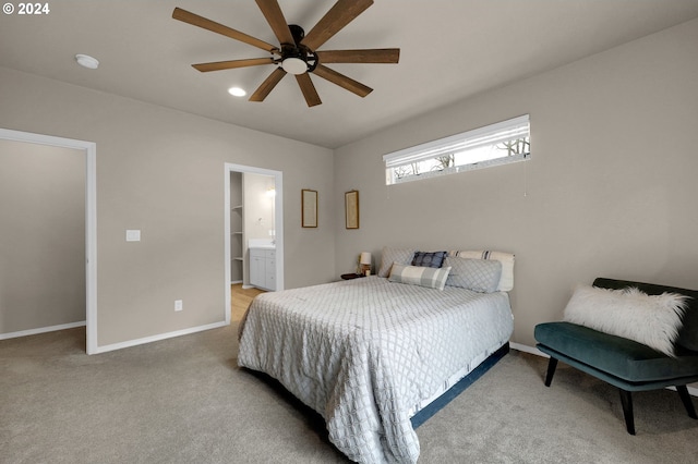 bedroom with light colored carpet, ceiling fan, and ensuite bath