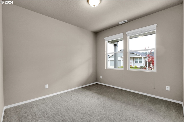 unfurnished room featuring carpet floors and a textured ceiling