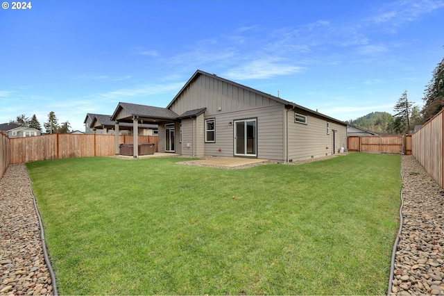 back of house with a patio area and a lawn