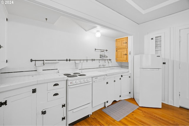 kitchen with white cabinets, light hardwood / wood-style floors, and white appliances