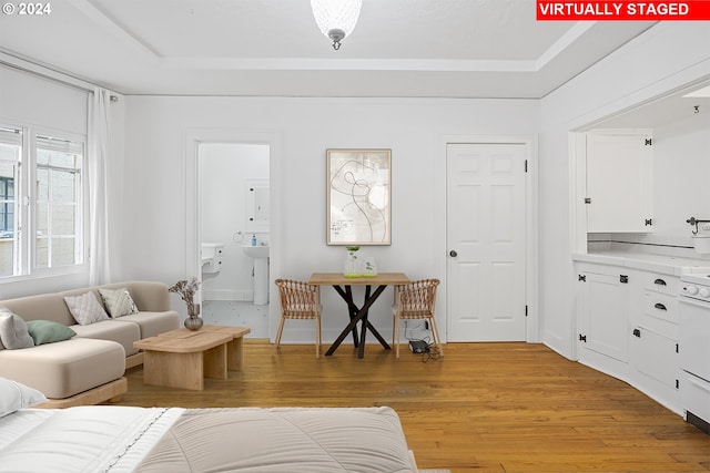 living room with light wood finished floors and a tray ceiling