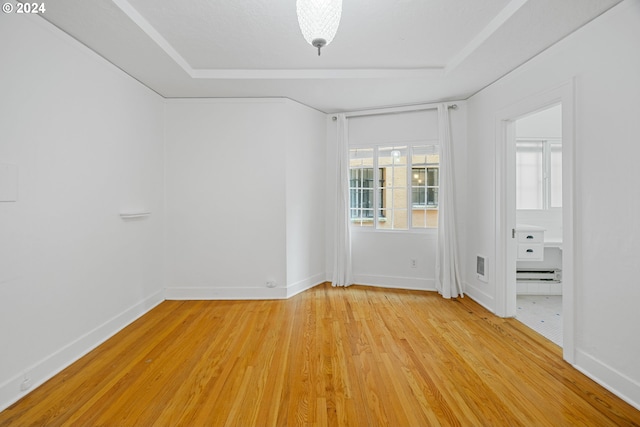 spare room featuring baseboards, visible vents, and light wood-style floors