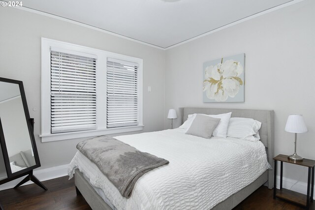 bedroom with dark hardwood / wood-style floors and ornamental molding