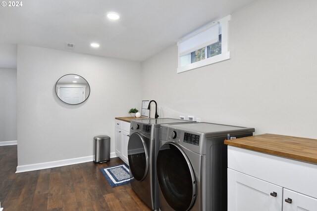 washroom with cabinets, dark hardwood / wood-style flooring, and washing machine and clothes dryer