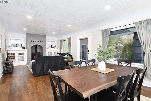 dining area with dark hardwood / wood-style flooring and a wood stove