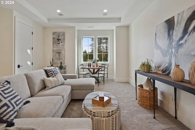 carpeted living room featuring a tray ceiling