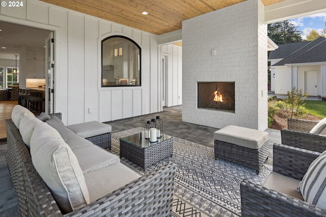 view of patio with an outdoor living space with a fireplace